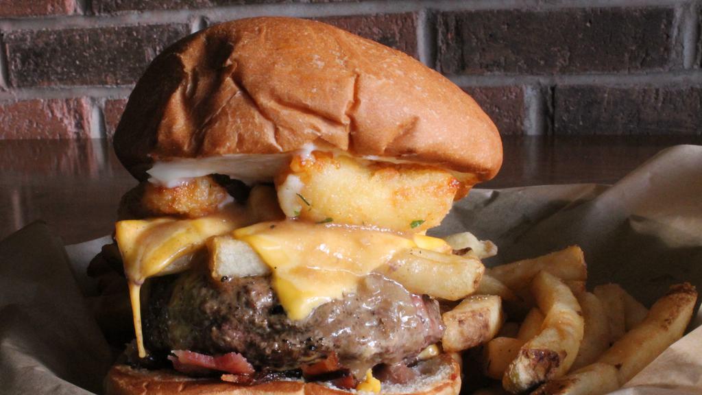 Poutine Lucy · American cheese-stuffed patty with chopped bacon, mayo, pub fries, American cheese, cheese curds and beef gravy.