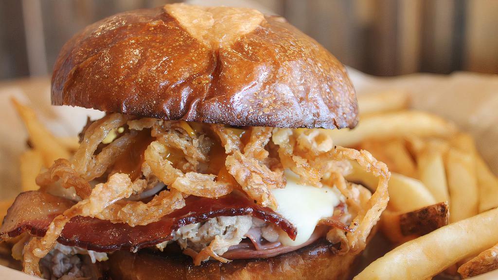 Hog Heaven · Ham, pulled pork, and bacon piled high on a pretzel bun with Monterey jack, haystack onions, Carolina gold BBQ sauce, and mayo.