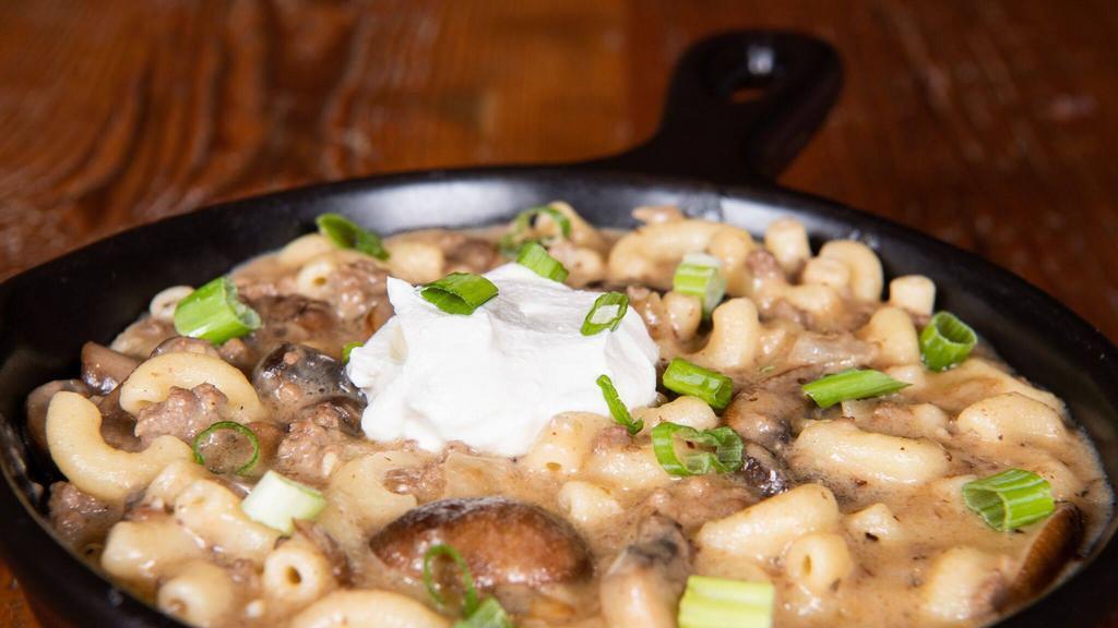 Beef Stroganoff · Ground beef, onions, garlic, cremini mushrooms, and macaroni noodles in stroganoff sauce. Topped with sour cream and green onions.