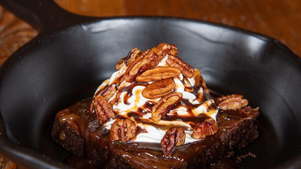 Turtle Brownie · Brownie topped with caramel and chocolate sauces, whipped cream, and glazed pecans. Add ice cream for an additional charge.