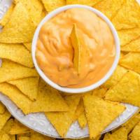 Queso · Delicious creamy queso with chips and salsa on the side.