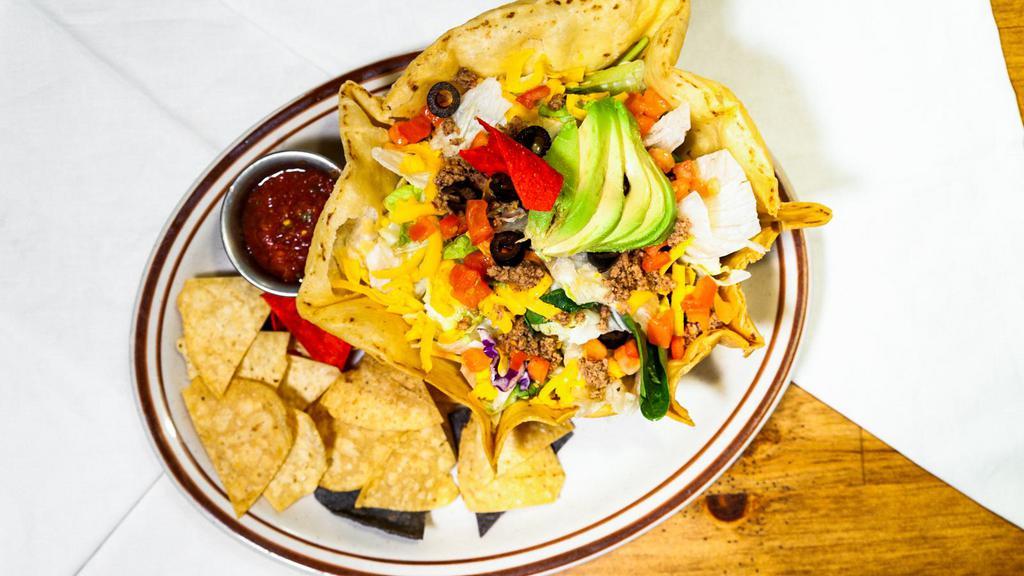 Taco Salad · Large fried flour tortilla shell filled with taco meat and beans. Topped with lettuce, tomato, avocado, black olives, and cheddar cheese. Served with salsa and tortilla chips.