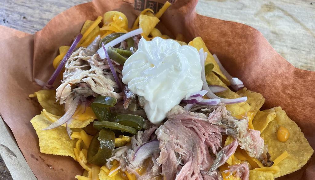 Nacho (L) · Corn Chip Nachos w/shredded cheese, in-house cheese sauce, option to add Pulled Pork, Brisket ($4) Jalapeños, Red Onion, Sour Cream. 
Served deconstructed to maintain integrity for take out & delivery.  (Meat & Cheese sauce in separate deli containers)