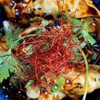 Szechuan Chili Dumplings · eight spicy beef and peanut dumplings served in our house chili oil sauce topped with scalli...