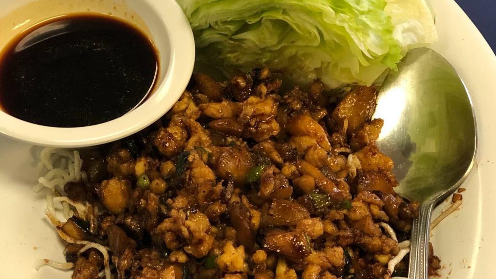 Chicken Lettuce Wrap · Wok seared minced white meat chicken with mushrooms,, water chestnuts, scallions, garlic and pepper soy, served over crispy rice sticks with Crispy Iceberg Lettuce