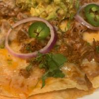 Carne Asada Mexican Pizza · Comes with Guacamole, Onions and Jalapeños on top.