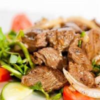 Steak Cubes · Lightly sautéed with garlic butter and caramelized onions, topped over lettuce.