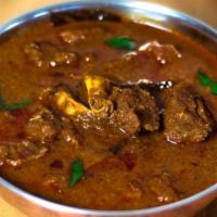 Goat Curry · Goat with bones cooked in tomatoes and onions in Punjabi style.
