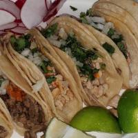 Taco Plate Pastor · Three pastor pork tacos with cilantro, onion, and sauce served with rice, and beans.