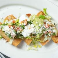 Taquitos Rancheros · New. Chicken taquitos topped with lettuce, pico de gallo, guacamole, sour cream, and queso f...