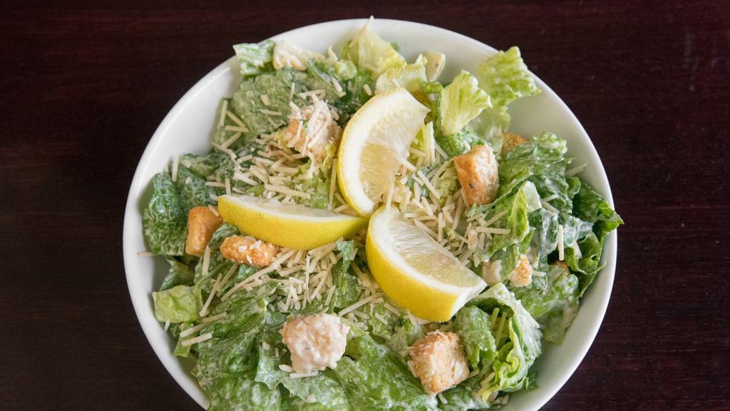 Caesar Salad · Romaine lettuce tossed with Caesar dressing, croutons, lemon and Parmesan cheese. Served with garlic bread.