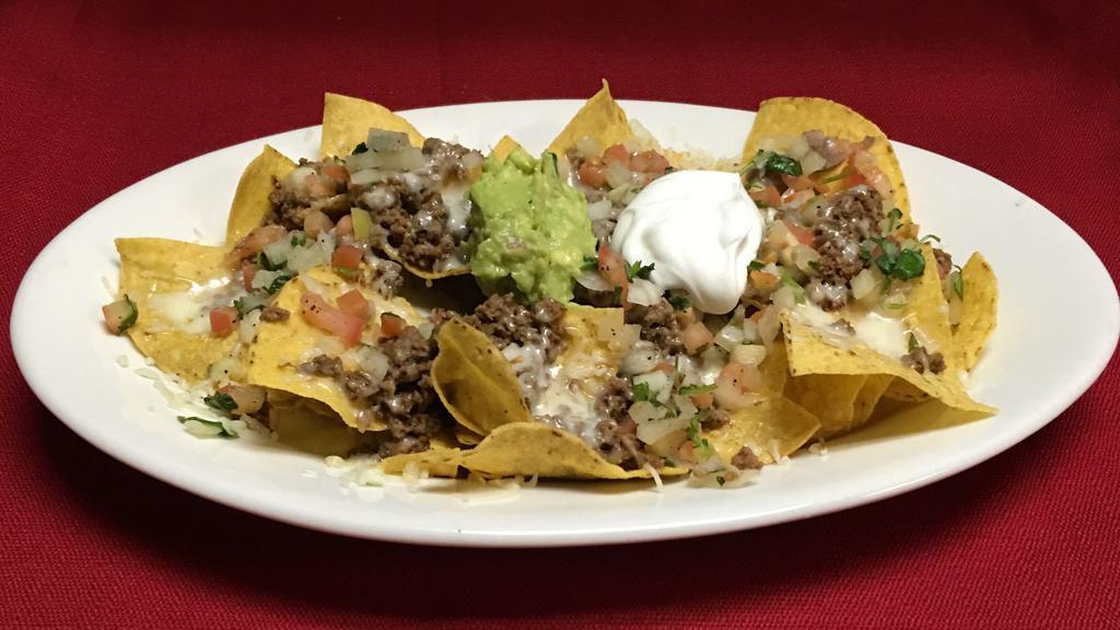 Meat Nachos · Our home made chips topped with your choice of meat,cheese,beans,sour cream,pico de gallo and guacamole.