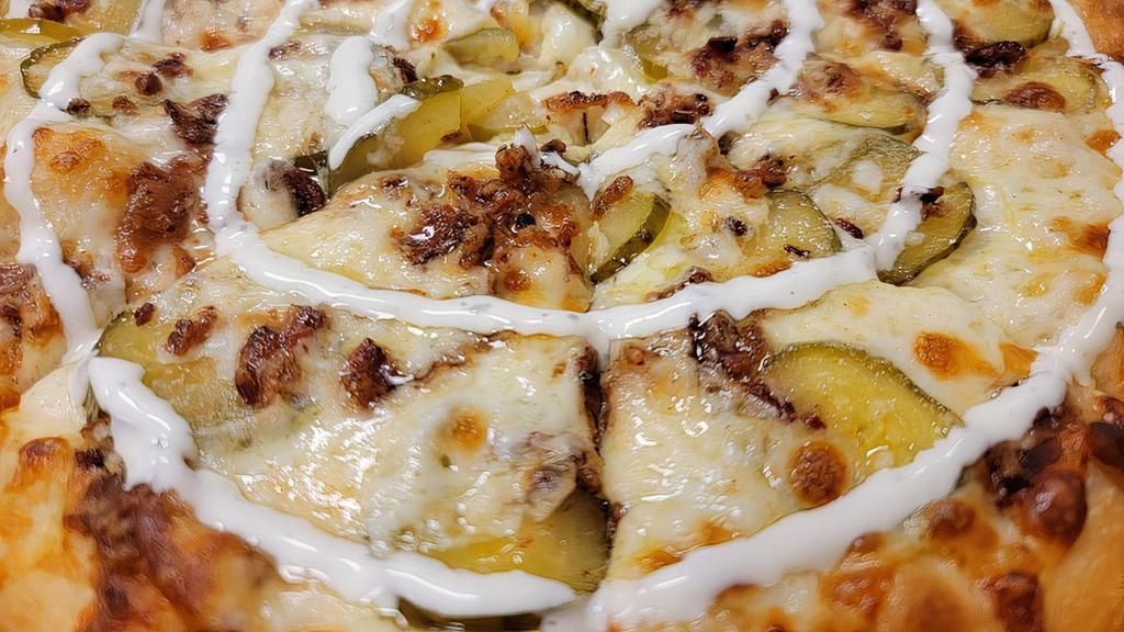Pickle Bacon Pizza · A butter garlic base topped with mozzarella cheese, cheddar bacon and sliced dill pickles with a homemade ranch swirl.