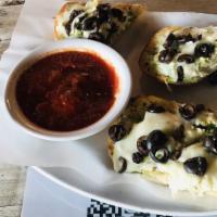 Pesto Cheese Bread · Garlic bread with feta, mozzarella, pesto, and black olives tossed with sunflower seeds.