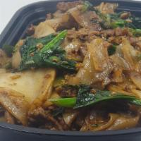Pad See  Ew · Wide rice noodles stir fried charred in a wok with broccoli and chinese broccoli with brown ...
