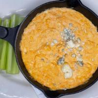 Buffalo Dip · Creamy blend of cheeses, chicken, and buffalo sauce. Served with celery, and tortilla chips.