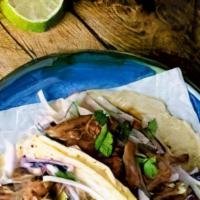Pulled Pork Tacos  · Pork meat marinated with Mexican spices  topped with cilantro , onion , tomatillo salsa, lim...