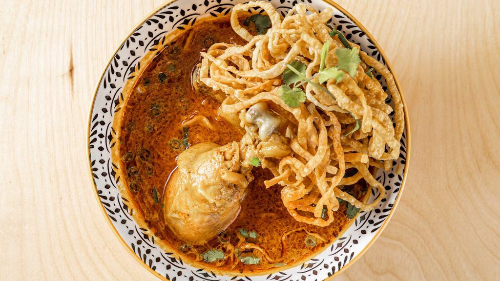 Khao Soi · Northern style curry sauce with egg noodle, green onion, shallots, fried onion, cilantro, lime and crispy egg noodle.