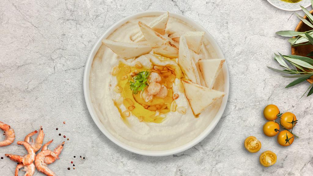 Vegan Homemade Hummus With Pita Bread · A mixture of mashed garbanzo beans, lemon juice and tahini, and served with pita bread.
