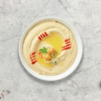 Hummus · A mixture of mashed garbanzo beans, and tahini, and served with pita bread.