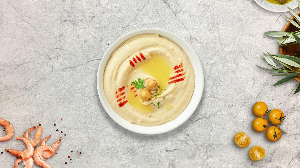 Hummus · A mixture of mashed garbanzo beans, and tahini, and served with pita bread.