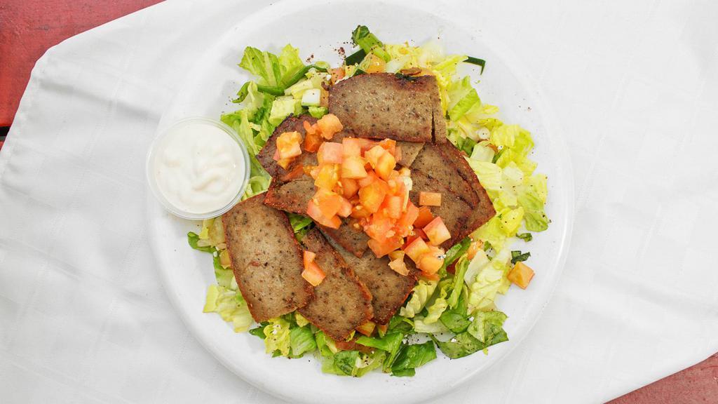 Lamb & Beef Gyro Over Salad · Seasoned grilled lamp and beef served over mixture of  lettuce, tomatoes, cucumbers mixed with our house Mediterranean dressing. Comes with tahini sauce on the side.