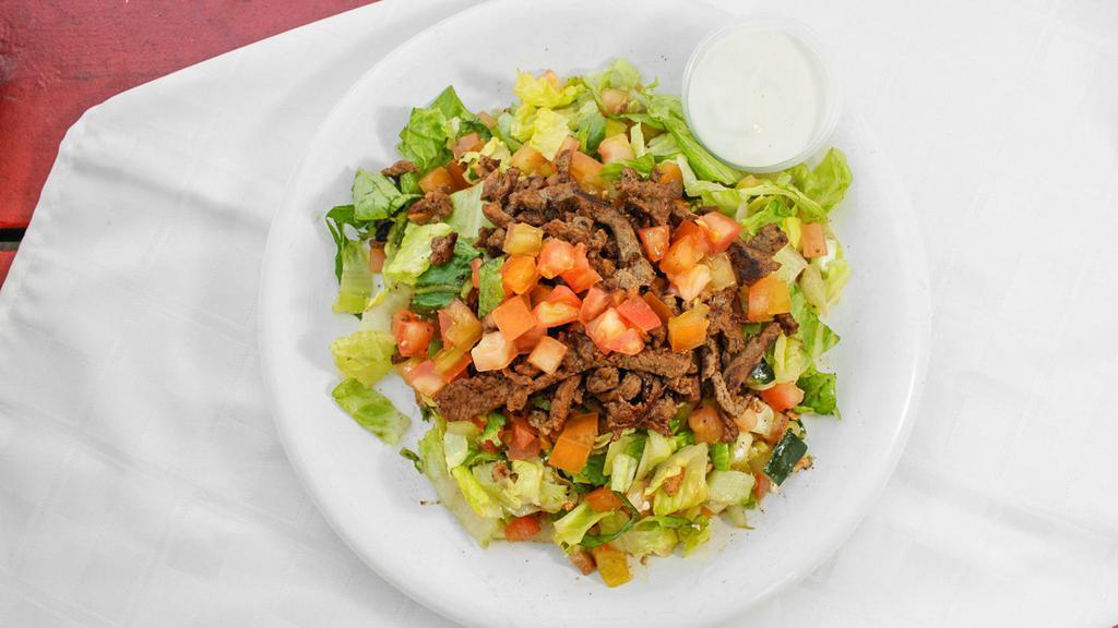 Beef Shawarma Over Salad · Marinated and seasoned beef grilled served over mixture of  lettuce, tomatoes, cucumbers mixed with our house Mediterranean dressing. Comes with tahini sauce on the side.