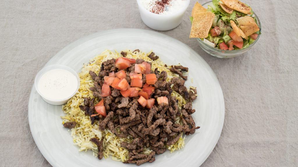Grilled Beef Shawarma Platter · Seasoned beef grilled. Served over basmati rice with Greek salad, fattoush salad, and tzatziki sauce.