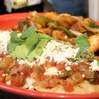 Huevos Rancheros · Two crispy corn tortillas topped with refried beans, two eggs any style, spicy ranchero sals...