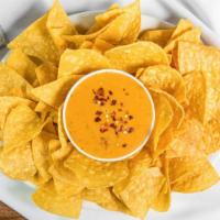 Chile Con Queso · Melty Green Chile and Cheese Dip. Served with Chips.