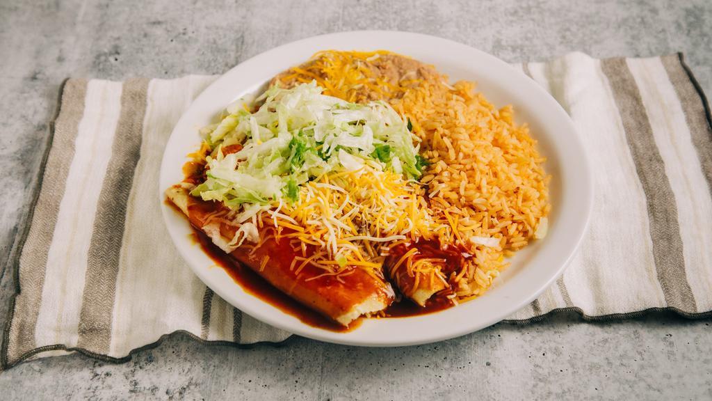 2 Enchiladas Plate · Two any meat enchiladas with enchilada sauce and lettuce on a plate with rice and beans.