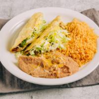 #2-  2 Beef Tacos Plate · Two beef tacos with lettuce and cheese on a plate with rice and beans.