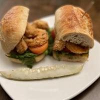 New Orleans Shrimp Po Boy Tg · a small plate w French bread sandwich w/ fried battered shrimp, tomato, shredded lettuce, an...
