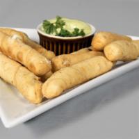 Tequeῆos (10Units) · Caribbean gourmet cheese sticks rolled in pastry dough served with garlic sauce.