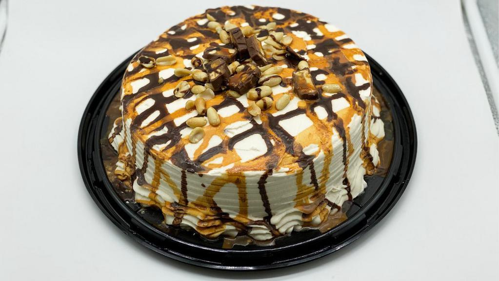 Snickers Cake · CHOCOLATE CAKE FILLED WITH CHOCOLATE, CARAMEL AND PEANUTS. COVERED WITH CREAM CHEESE FROSTING AND DECORATED WITH CHOCOLATE, CARAMEL, SNICKERS AND PEANUTS.