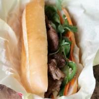 Banh Mi Grilled Pork · French baguette served with homemade butter, fried onion, cucumber, cilantro, jalapeno, pick...