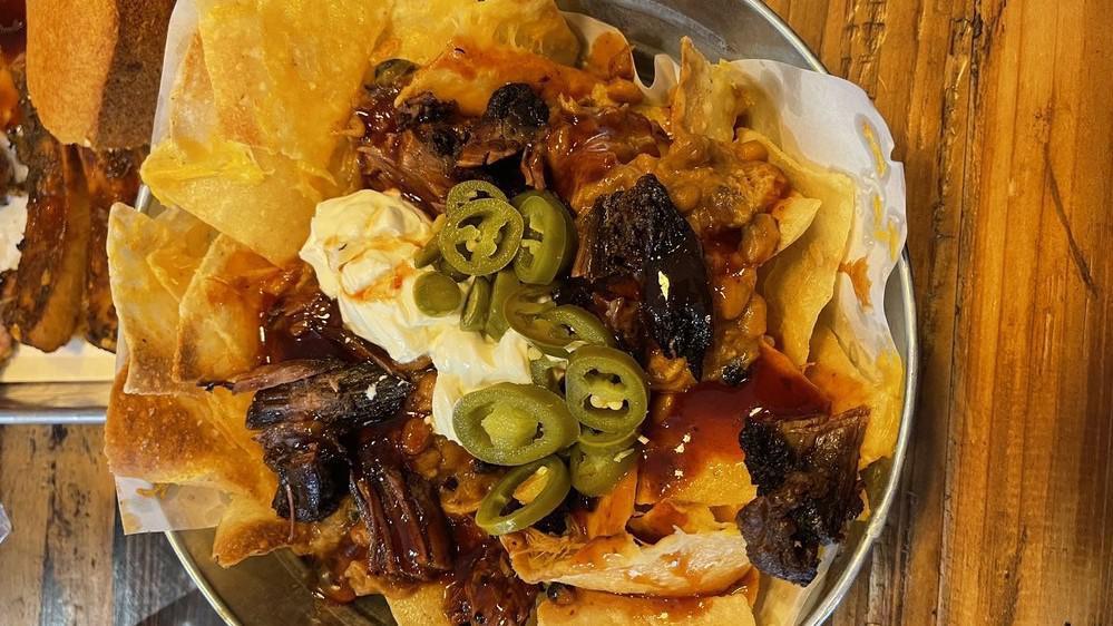 Bbq Nachos · Tortilla chips covered with melted cheese, your choice of meat, bbq beans, sour cream, jalapenos, and a drizzle of bbq sauce