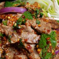 Num Tok Beef · Grilled steak and sliced mixed with mint, red onion, green onion, cilantro, chili, ground ri...