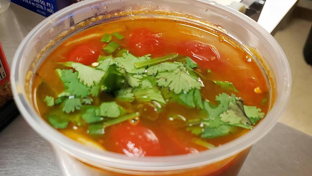 Tom Yum · Hot and sour soup with chili paste, galangal, lemongrass, kaffir lime leaves, mushrooms, tomato, onion, lime juice, fish sauce, green onion, and cilantro.