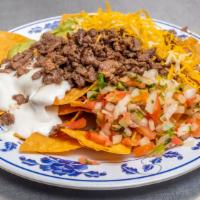 Super Nachos · Corn tortilla chips topped with carne asada, beans, guacamole, cheese and sour cream.