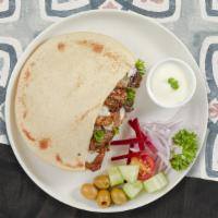 Meaty Shawarma Combo Pita · Marinated chicken and beef, hummus, lettuce, red cabbage, red onion, tahini, tzatziki, and h...
