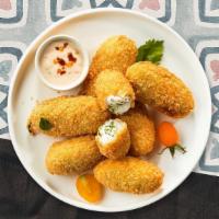 Popper Stopper · Six pieces of crispy golden jalapenos stuffed with creamy cheese and served with savory mari...