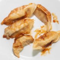 Gyoza · Pan sautéed pork and vegetable dumplings.