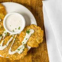 Tostones (Twice-Fried Green Plantains) · Served with mojito sauce.