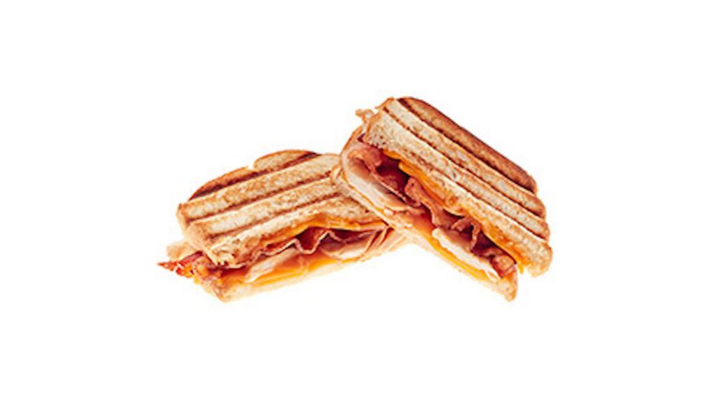 Turkey Melt Panini · Roasted turkey, bacon, cheddar cheese, and rustic Thousand Island Dressing. Served on grilled sourdough bread.