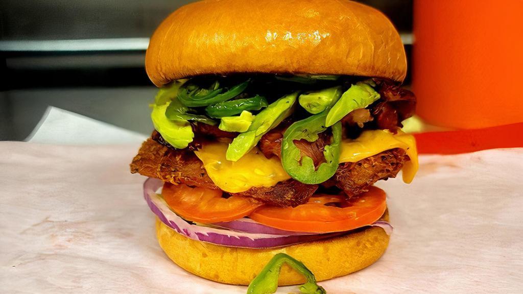 Crafty Cali · Crispy fried chicken, american cheese, bacon, avocado, jalapeno, lettuce, tomato, onion  on a brioche bun with french fries.