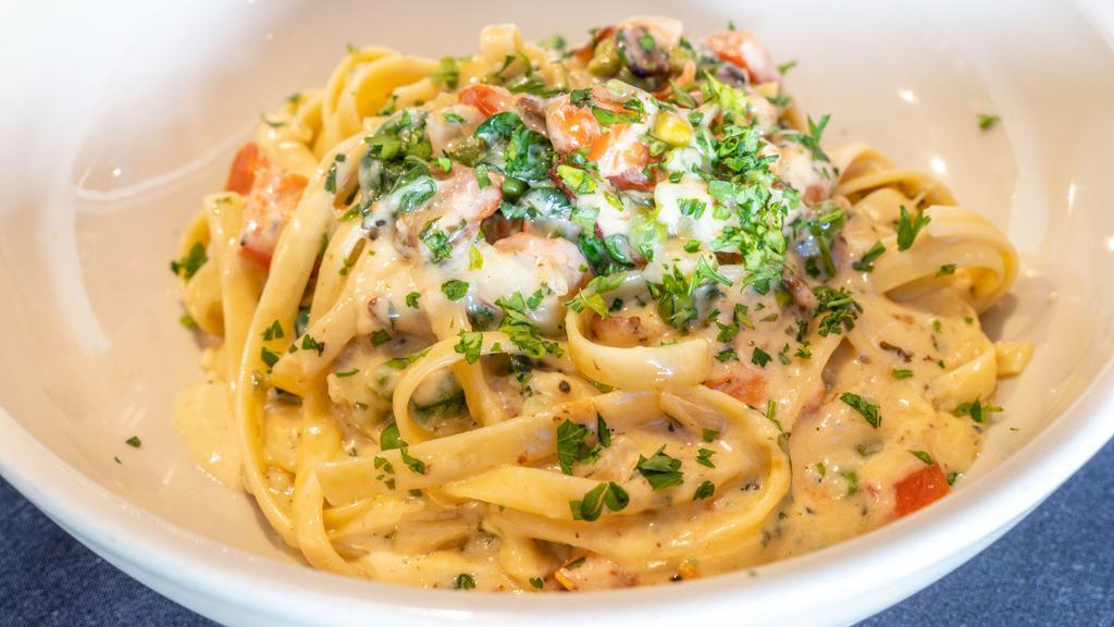 Pork Carbonara · Grilled Pork, fresh peas, 
 onion, bacon, tomato sautéed with garlic white and tossed in a parmesan cream sauce served with fettuccini pasta.