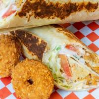 Falafel Saj · 7 pieces of falafel, hummus, lettuce, tomatoes, pickles, fresh onions, topped with the tzatz...