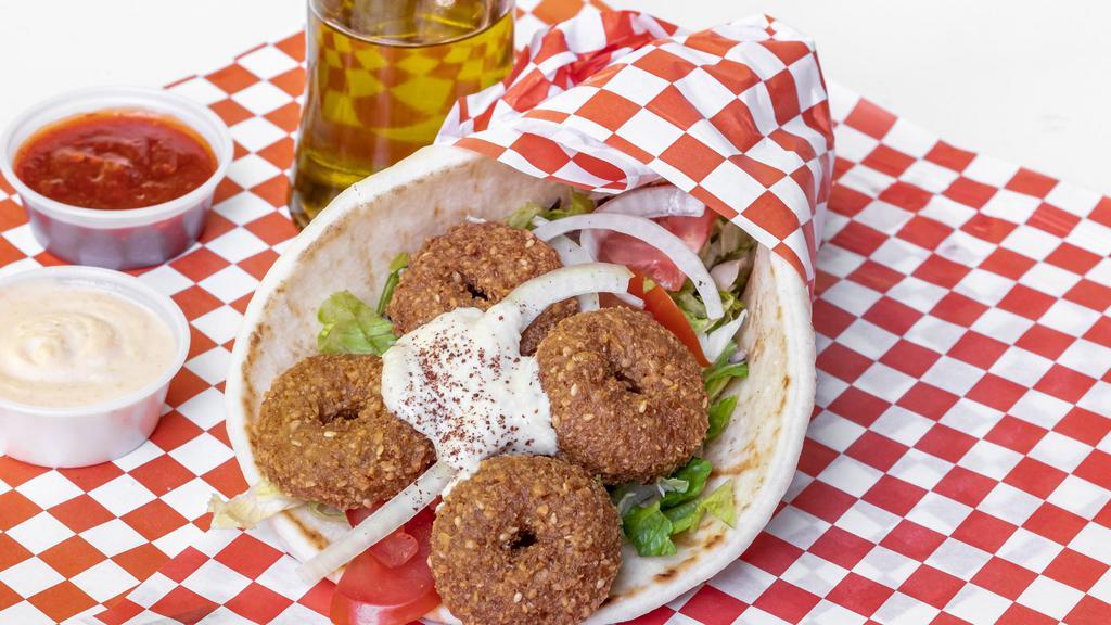Falafel Gyro · 5 pieces falafel rolled with bread pita lettuce, tomatoes, pickles, onions, hummus, and tzatziki. Add an extra piece of falafel for an additional charge.