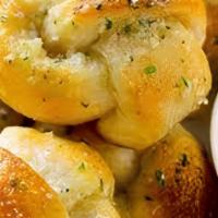 Garlic Knots. · Our house made pizza dough, knotted up, baked, then smothered in real garlic butter and parm...